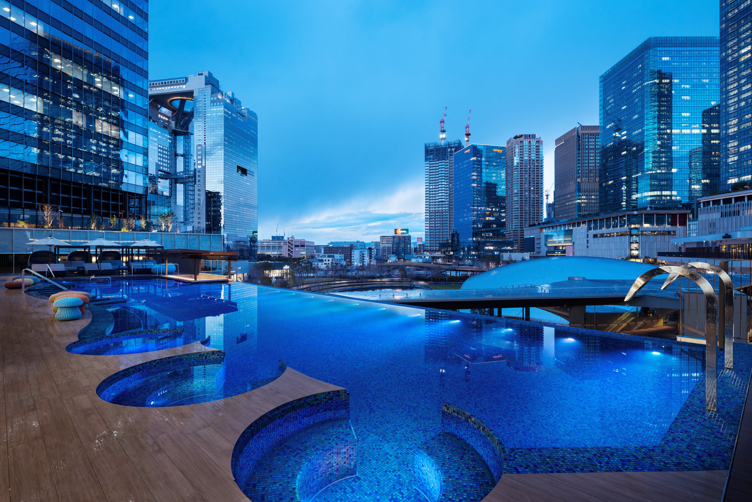 夜の屋外プールから見たうめきた温泉 蓮 Wellbeing Parkの外観